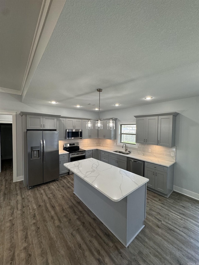 kitchen featuring sink, a center island, tasteful backsplash, hanging light fixtures, and appliances with stainless steel finishes