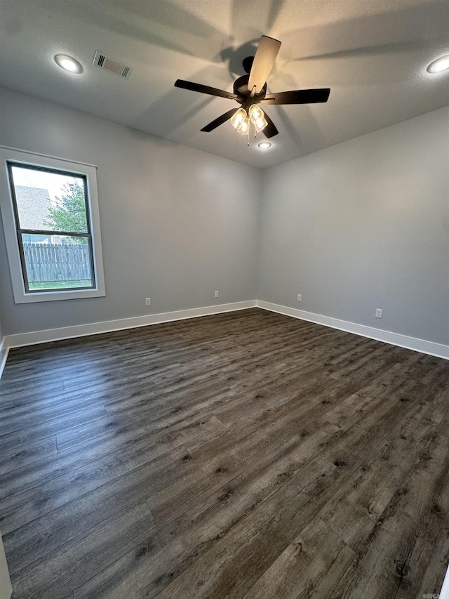 spare room with ceiling fan and dark hardwood / wood-style flooring