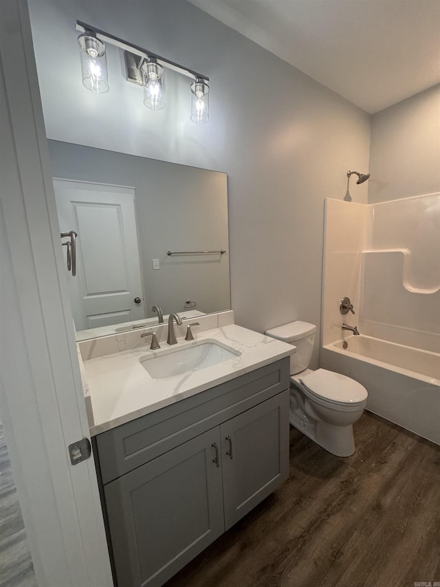 full bathroom featuring shower / bath combination, vanity, hardwood / wood-style flooring, and toilet