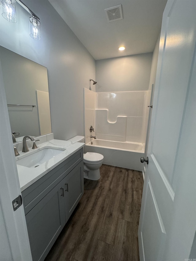 full bathroom featuring toilet, wood-type flooring, vanity, and shower / bath combination