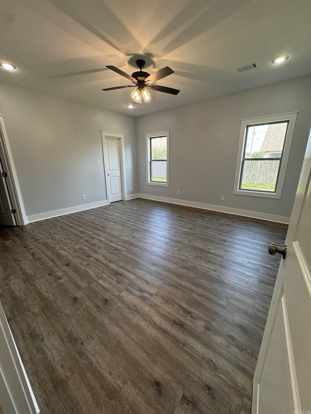 empty room with dark hardwood / wood-style flooring and ceiling fan