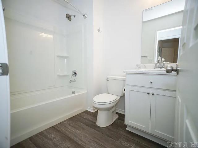 full bathroom featuring toilet, shower / washtub combination, vanity, and hardwood / wood-style floors