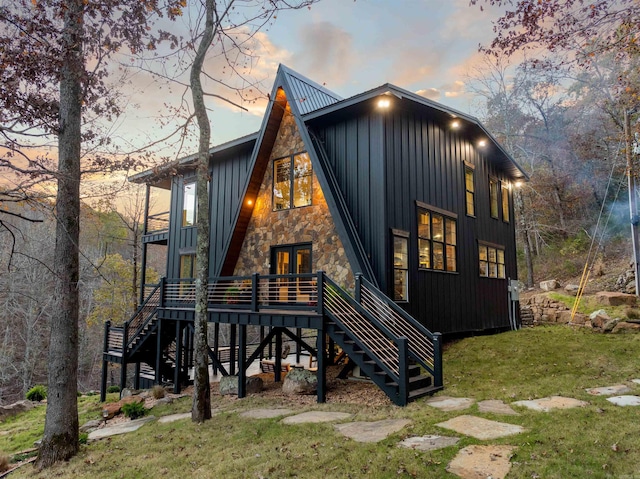 back house at dusk featuring a deck and a yard