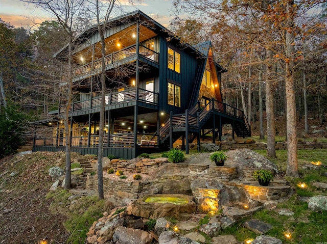 back house at dusk featuring a balcony