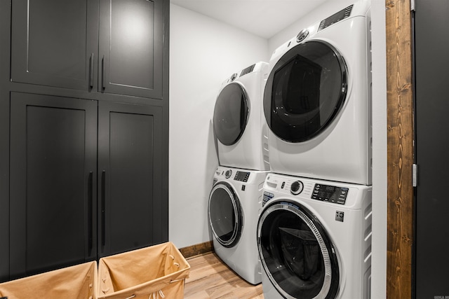 laundry room featuring stacked washing maching and dryer and hardwood / wood-style floors