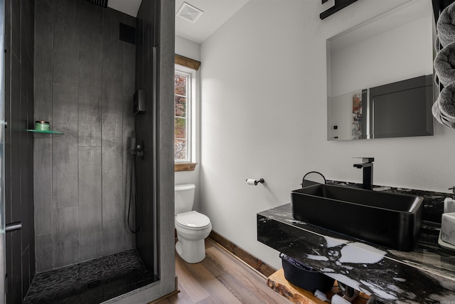 bathroom with sink, walk in shower, hardwood / wood-style floors, and toilet