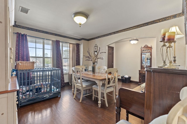 dining room with ornamental molding and dark hardwood / wood-style flooring