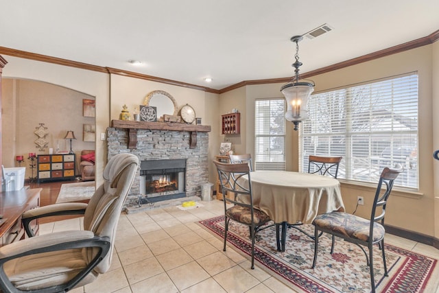 dining room with crown molding, a fireplace, and light tile patterned floors