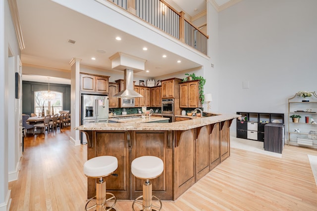 kitchen with island exhaust hood, ornamental molding, decorative backsplash, and a kitchen breakfast bar