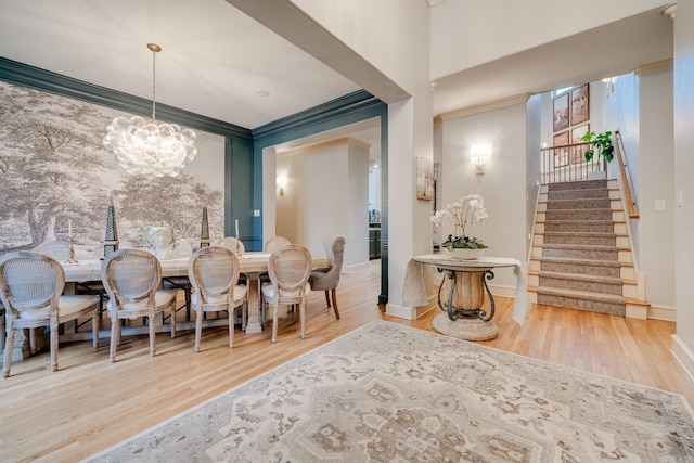 dining space with ornamental molding, a chandelier, and hardwood / wood-style flooring