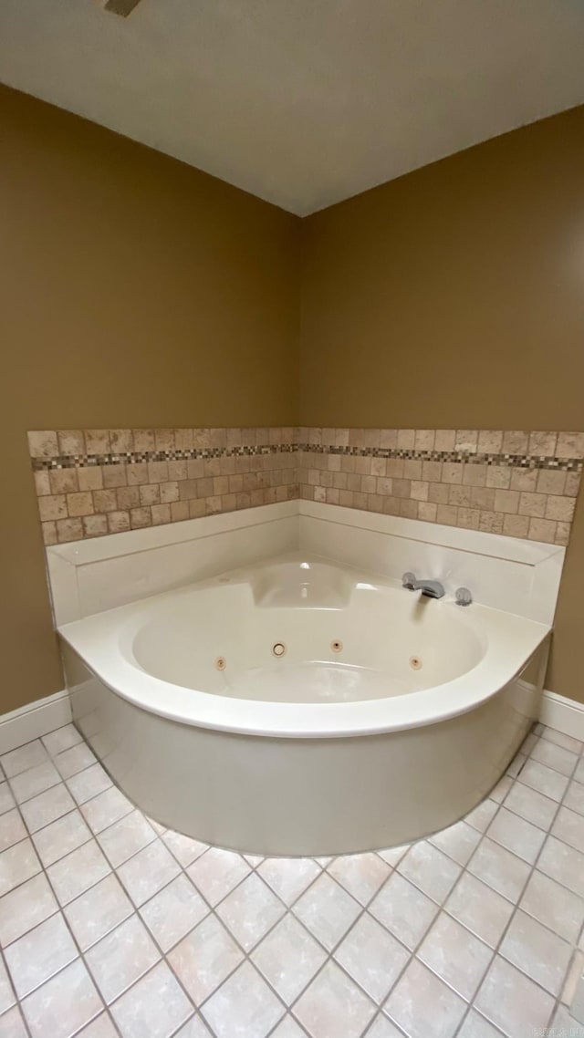 bathroom with tile patterned flooring and a bath