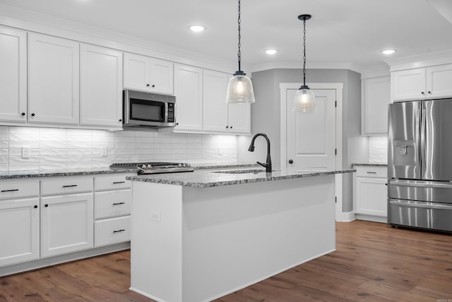 kitchen with sink, white cabinets, appliances with stainless steel finishes, and a kitchen island with sink