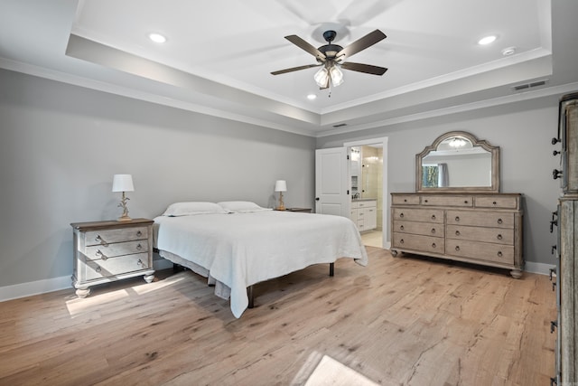 bedroom with ceiling fan, connected bathroom, and a tray ceiling