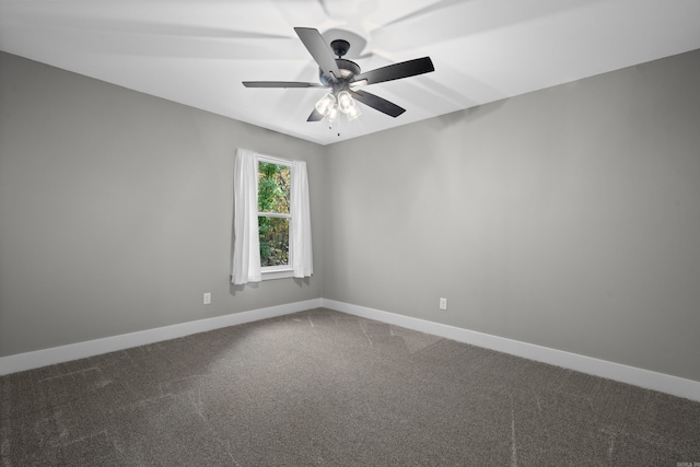 empty room with ceiling fan and dark carpet