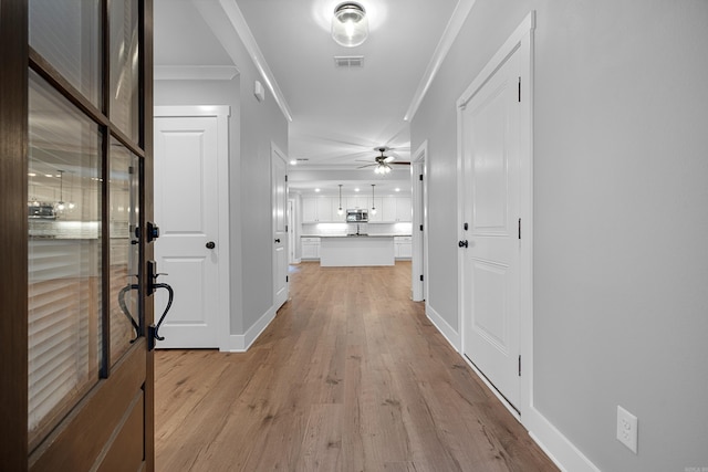 hall featuring light hardwood / wood-style floors and crown molding