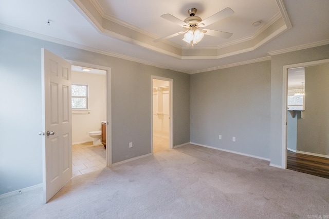 unfurnished bedroom featuring a raised ceiling and ornamental molding