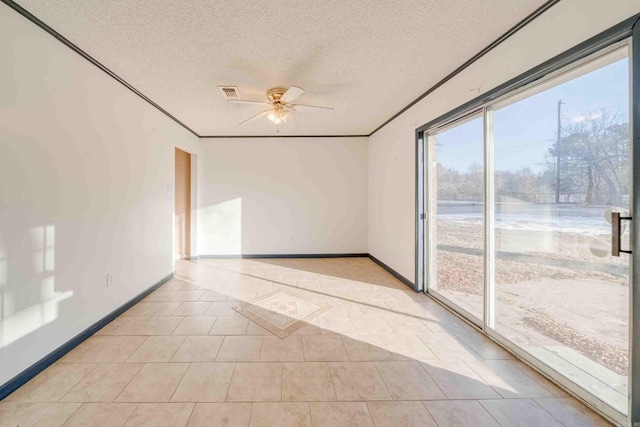 spare room featuring a textured ceiling, ceiling fan, light tile patterned floors, and ornamental molding