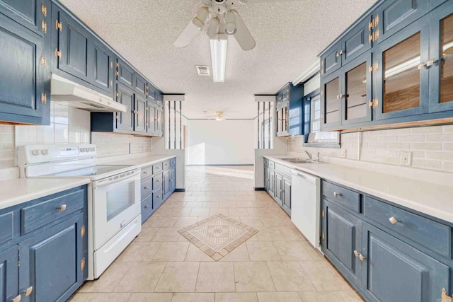 kitchen with ceiling fan, blue cabinetry, white appliances, light tile patterned flooring, and sink