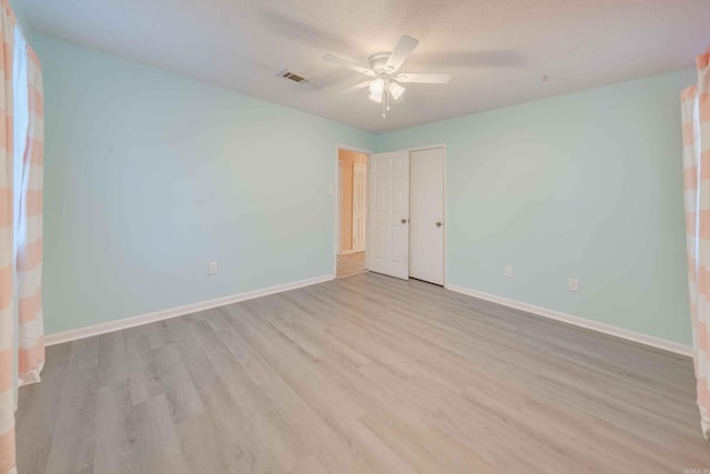 unfurnished bedroom featuring a textured ceiling, ceiling fan, and light hardwood / wood-style flooring