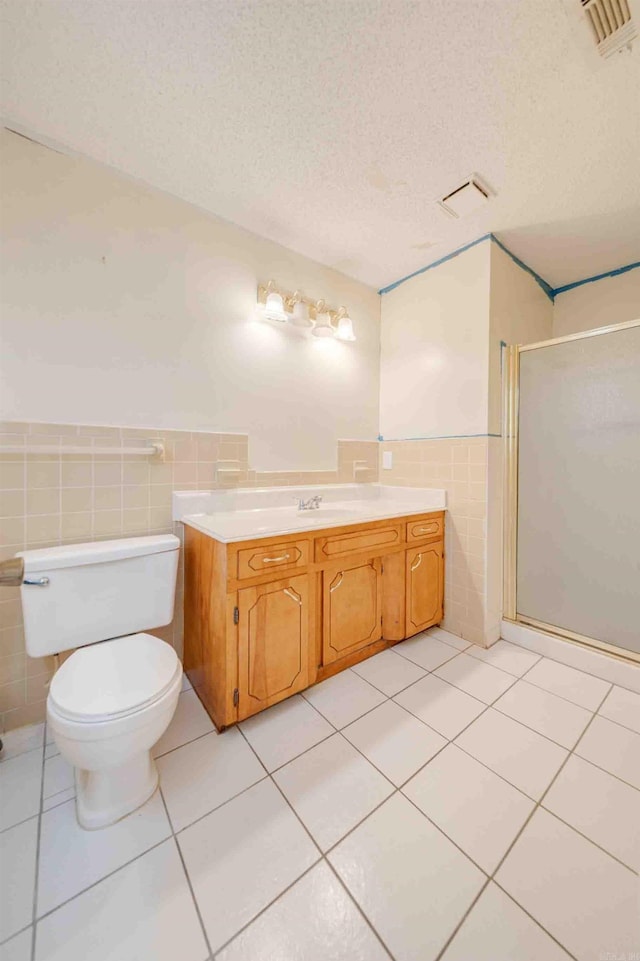 bathroom featuring toilet, tile walls, walk in shower, a textured ceiling, and vanity