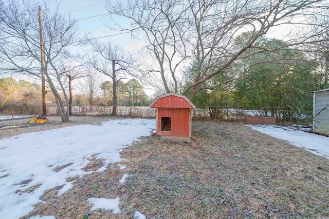 yard covered in snow featuring a shed