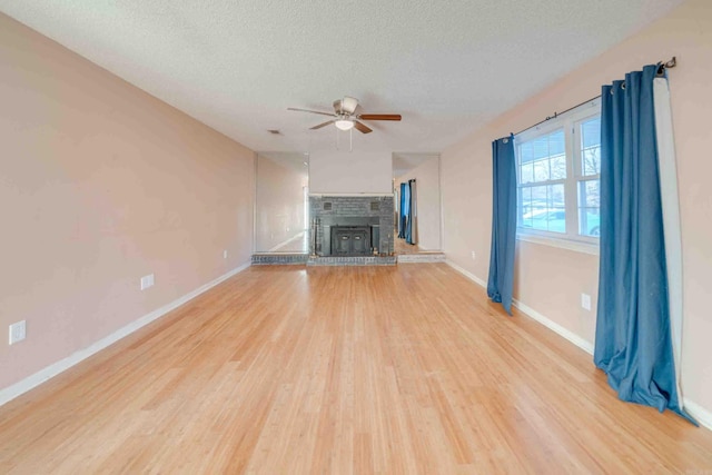 unfurnished living room with a textured ceiling, ceiling fan, and light hardwood / wood-style floors