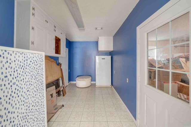 bathroom with a textured ceiling and tile patterned flooring