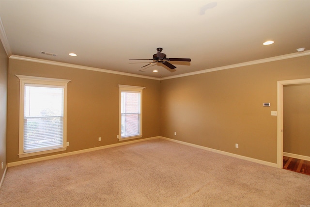 carpeted spare room featuring ceiling fan and crown molding