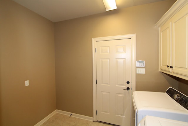 laundry room with washing machine and dryer and cabinets