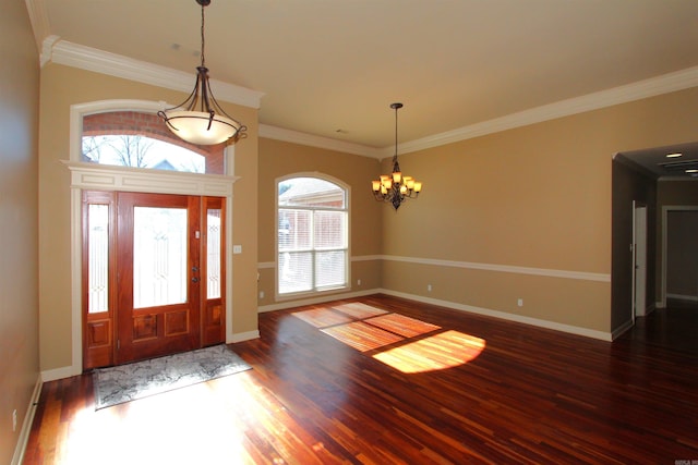 foyer with ornamental molding, dark hardwood / wood-style flooring, and a notable chandelier