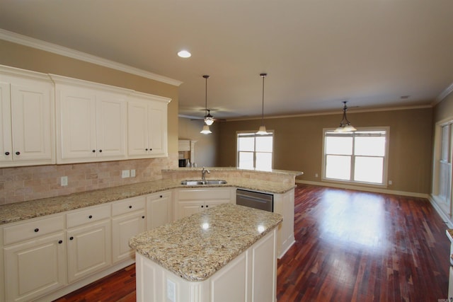 kitchen featuring sink, white cabinets, a center island, and kitchen peninsula