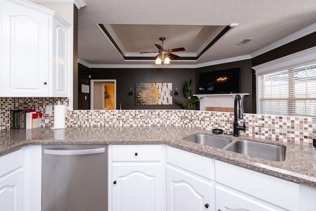 kitchen featuring tasteful backsplash, a raised ceiling, sink, white cabinetry, and ornamental molding