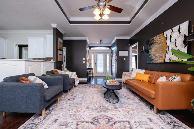 living room with ceiling fan, ornamental molding, light hardwood / wood-style flooring, and a tray ceiling