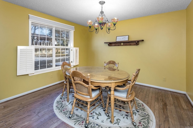 dining room featuring hardwood / wood-style floors, a textured ceiling, and a notable chandelier