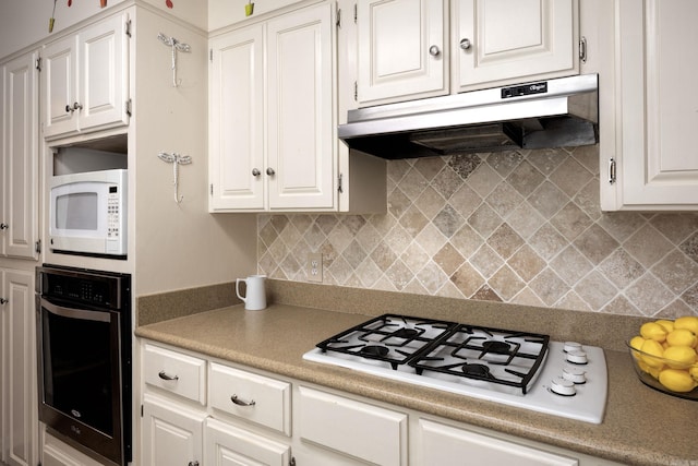 kitchen with white cabinets, decorative backsplash, and white appliances