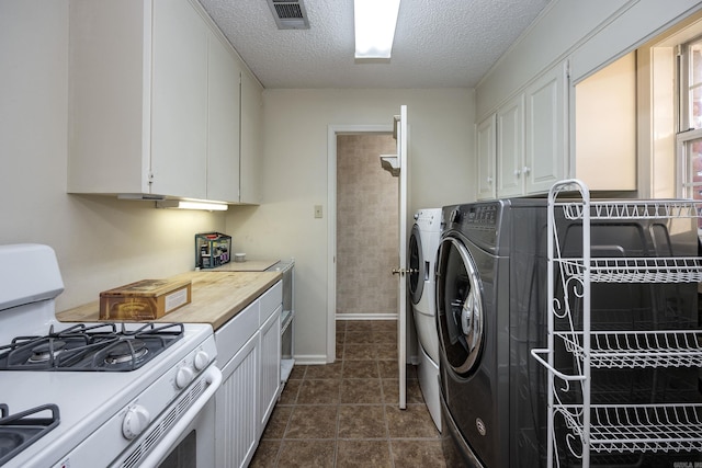 washroom with a textured ceiling and washer and clothes dryer