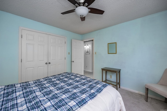 bedroom with a textured ceiling, ceiling fan, a closet, and carpet floors