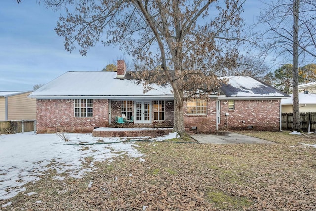 snow covered rear of property featuring a patio