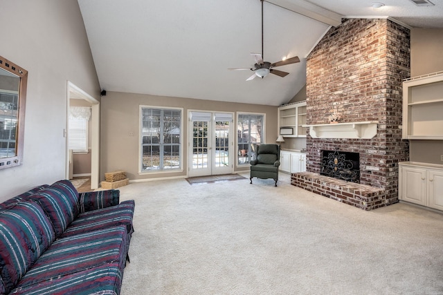 living room with french doors, vaulted ceiling with beams, ceiling fan, a brick fireplace, and light colored carpet