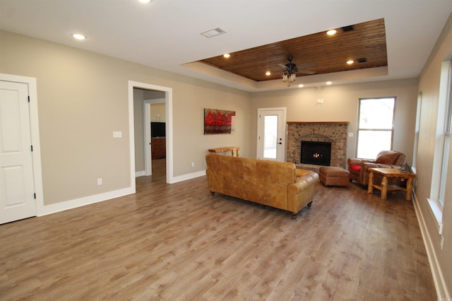 living room with a raised ceiling, ceiling fan, wood ceiling, and light hardwood / wood-style flooring