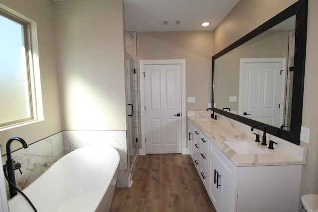 bathroom featuring hardwood / wood-style flooring, vanity, and separate shower and tub