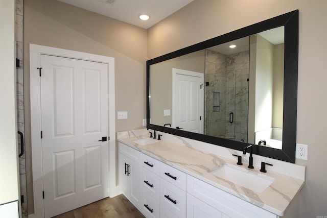 bathroom featuring a shower with shower door, vanity, and hardwood / wood-style flooring