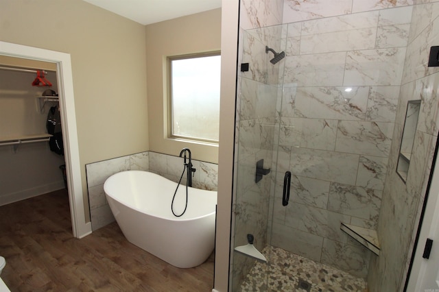 bathroom with hardwood / wood-style flooring and separate shower and tub