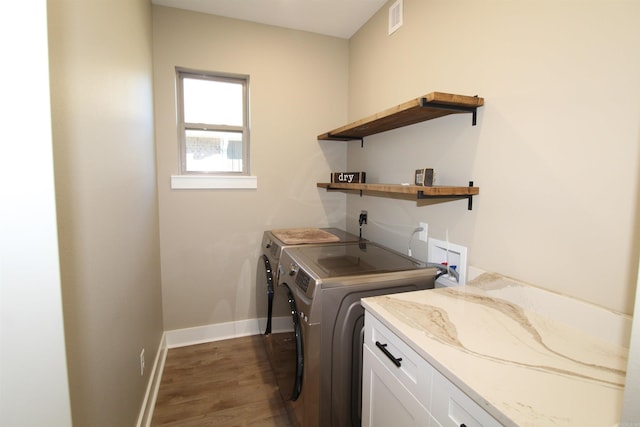 clothes washing area featuring washing machine and dryer, cabinets, and dark wood-type flooring