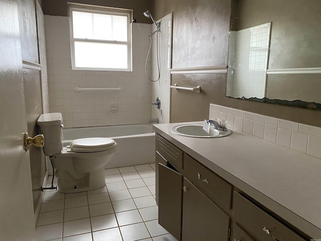 full bathroom featuring toilet, vanity, tiled shower / bath, and tile patterned flooring