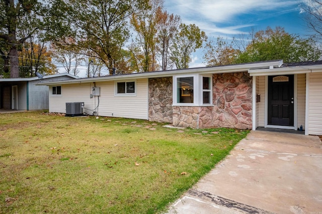 view of front of home with a front lawn and central AC unit