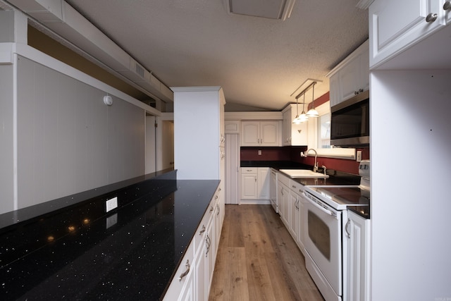 kitchen featuring decorative light fixtures, vaulted ceiling, sink, white cabinetry, and white electric range oven