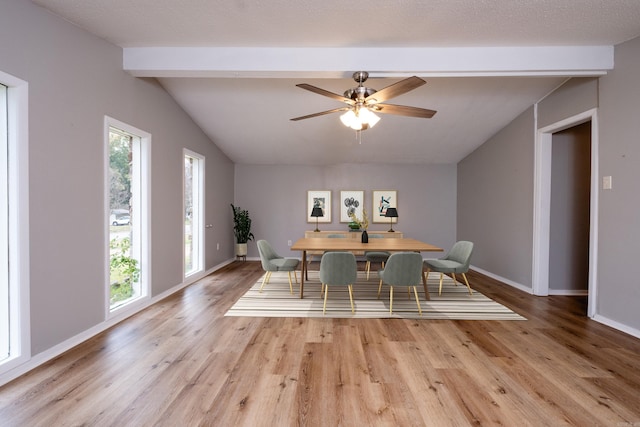 dining area with light wood-type flooring, ceiling fan, and vaulted ceiling with beams