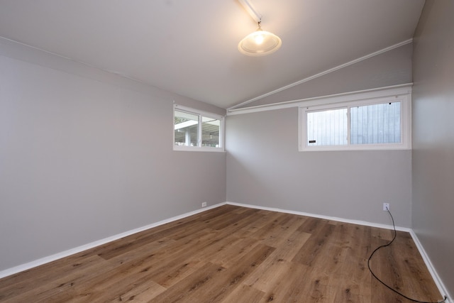 empty room featuring hardwood / wood-style floors and vaulted ceiling