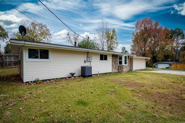 back of property featuring central air condition unit and a lawn